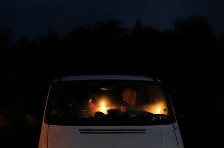 Orthodox Christian pilgrims hold candles inside a minibus on the eve of the Elevation of the Cross holiday at Krustova Gora (Holly Cross Forest), Bulgaria, September 13, 2018. REUTERS/Stoyan Nenov