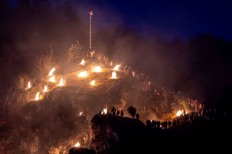 Mountain bonfires burn on the rocky slopes around the town on Epiphany on the occasion of the Catholic Feast of Perpetual Adoration. Pia Bayer/dpa