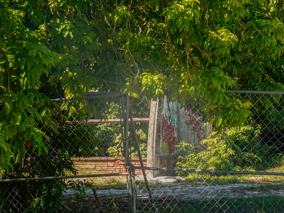 Abandoned structures beyond a fence