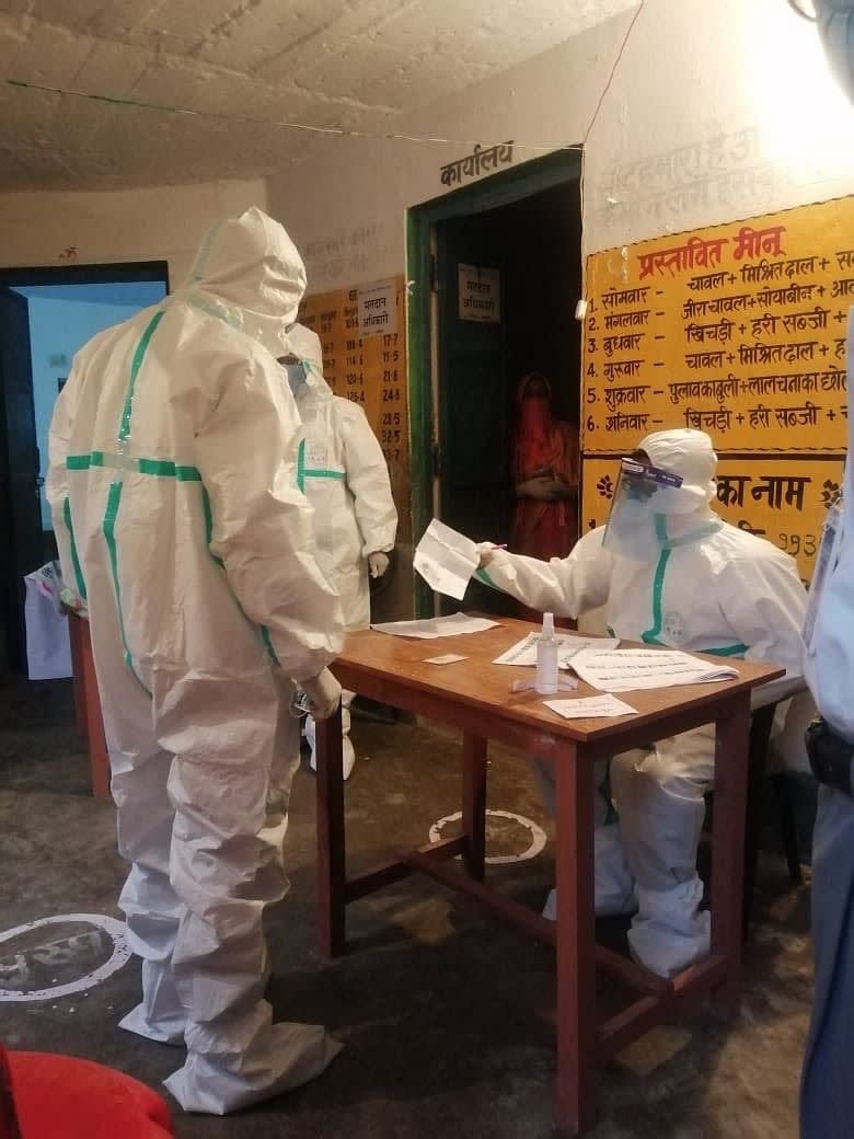 In the last hour of polling at Chausa Narayanpur booth number 222 of Buxar Assembly constituency, polling personnel, wearing PPE kits, cast their votes. 