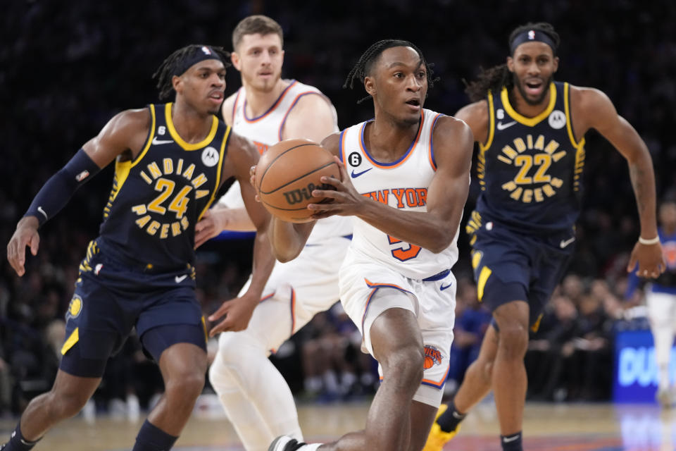 New York Knicks guard Immanuel Quickley (5) drives to the basket past Indiana Pacers forward Isaiah Jackson (22) and guard Buddy Hield (24) in the second half of an NBA basketball game, Wednesday, Jan. 11, 2023, at Madison Square Garden in New York. (AP Photo/Mary Altaffer)