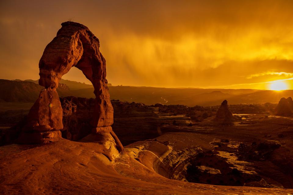 The sun sets as a rainstorm blows over Delicate Arch in Arches National Park near Moab on Saturday, Sept. 18, 2021. | Spenser Heaps, Deseret News