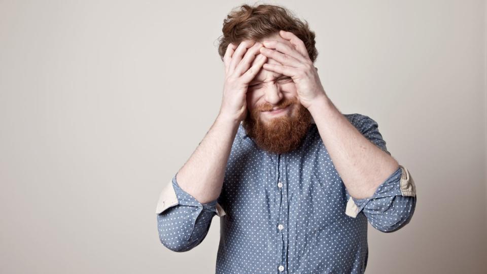 Man with hands on head and pained face