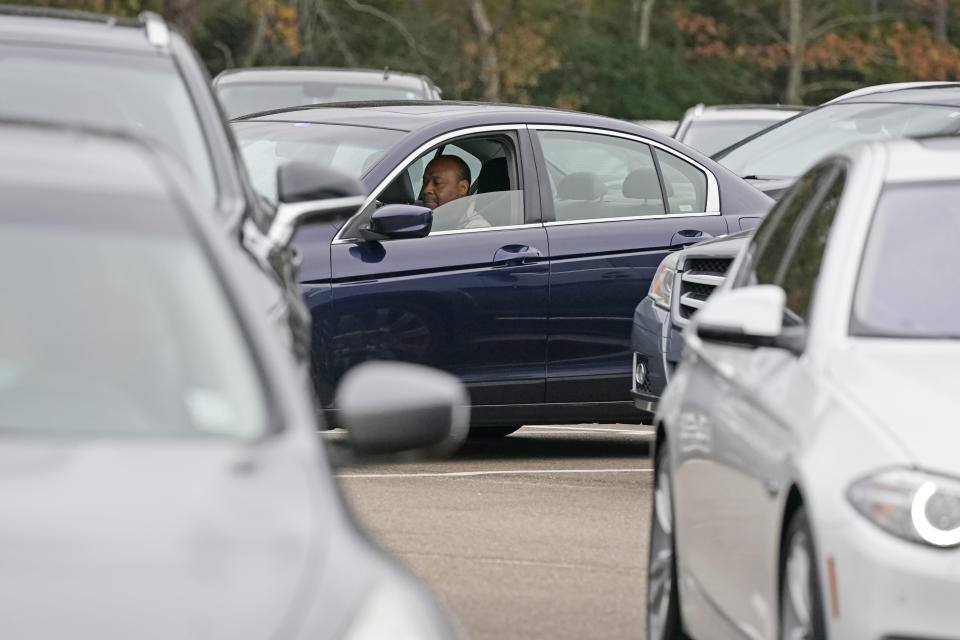 Anderson United Methodist Church member Robert Johnson sits in his car in the church's parking lot and listens as senior pastor Rev. Joe May delivers his First Sunday sermon to his church members via a live digital stream to the church's website and its Facebook page in addition to being broadcast on a local FM station, Dec. 6, 2020, in Jackson, Miss. Because of covid, the church has embraced the digital means by which to air the Sunday services to its members. However, for First Sunday services, the members will gather in the church's parking lot to celebrate the receiving of communion in their personal vehicles. (AP Photo/Rogelio V. Solis)