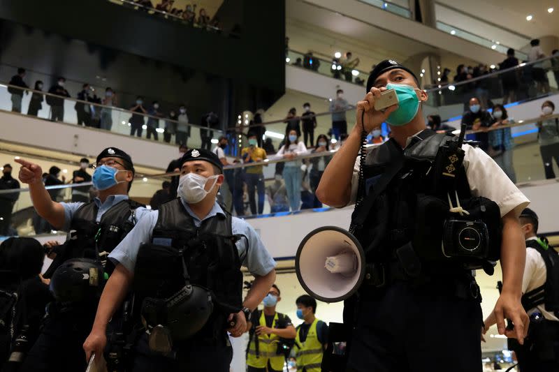 Police wearing face masks to avoid the spread of the coronavirus disease (COVID-19) as they disperse anti-government protesters from a shopping mall after a rally in Hong Kong