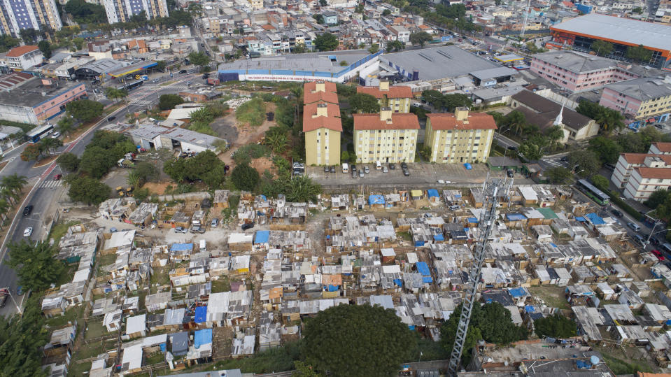 FILE - This May 15, 2021 file photo shows an aerial view of the Penha Brasil favela where families have started relocating during the coronavirus pandemic in Sao Paulo, Brazil. The pandemic shantytown sprang up virtually overnight when people began using scavenged wooden boards to build shacks on a plot of empty land in Sao Paulo, Brazil's biggest city. (AP Photo/Andre Penner, File)