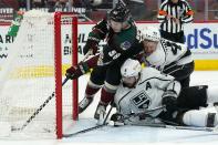 Arizona Coyotes left wing Michael Bunting (58) pushes the puck further into the net on a goal by Jakob Chychrun as Los Angeles Kings defensemen Drew Doughty (8) and Kings Mikey Anderson (44) defend in vain during the first period of an NHL hockey game Wednesday, May 5, 2021, in Glendale, Ariz. (AP Photo/Ross D. Franklin)