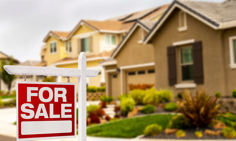 A "For Sale" sign in front of a home