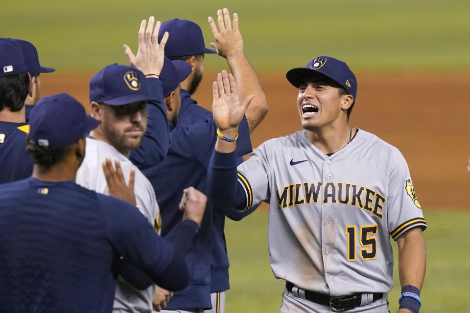 Milwaukee Brewers' Tyrone Taylor (15) high- fives his teammates after the Brewers defeated the Miami Marlins 6-2 in a baseball game, Saturday, May 8, 2021, in Miami. (AP Photo/Lynne Sladky)
