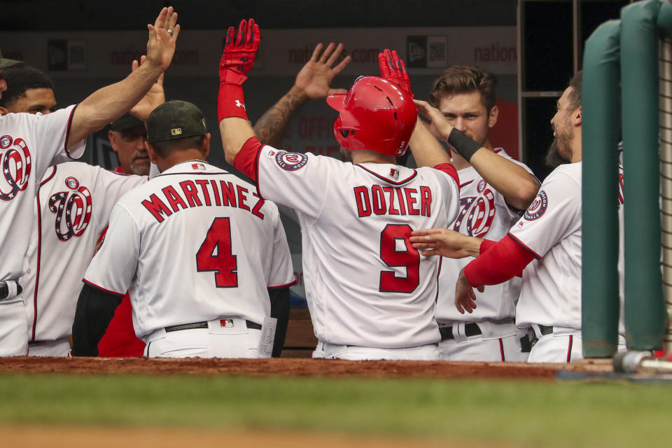 Washington Nationals' Brian Dozier (9) high-fives teammates after hitting a solo home run during the second inning of the team's baseball game against the Chicago Cubs, Saturday, May 18, 2019, in Washington. (AP Photo/Andrew Harnik)