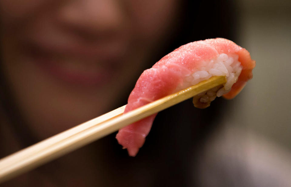 sushi held in chopsticks