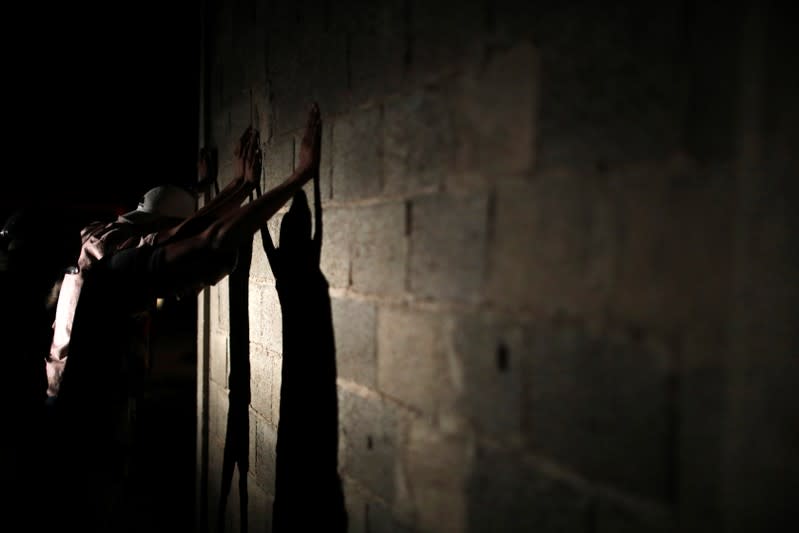 Members of the FAES stop people during a night patrol, in Barquisimeto