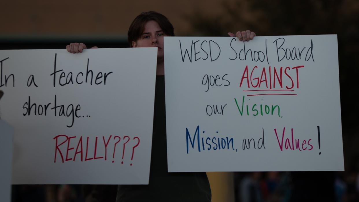 March 9, 2023; Glendale, AZ, USA; Alexis Watson holds signs at a protest at the Washington Elementary School District office on March 9, 2023, in Glendale. Mandatory Credit: Mingson Lau/The Republic