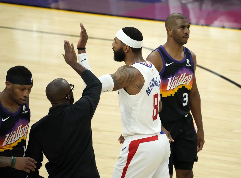 Clippers forward Marcus Morris Sr. (8) celebrates as Phoenix Suns guard Chris Paul (3) walks to the bench during Game 5 of the Western Conference Finals, June 28, 2021, in Phoenix.