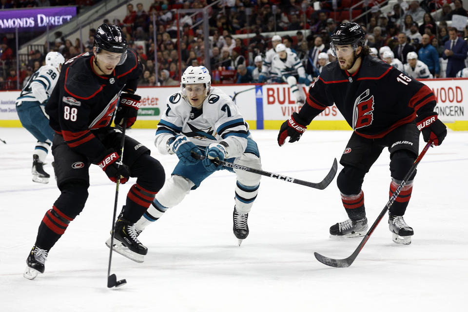 Carolina Hurricanes' Martin Necas (88) controls the puck past San Jose Sharks' Nico Sturm (7) with Hurricanes' Dylan Coghlan (15) nearby during the first period of an NHL hockey game in Raleigh, N.C., Friday, Jan. 27, 2023. (AP Photo/Karl B DeBlaker)
