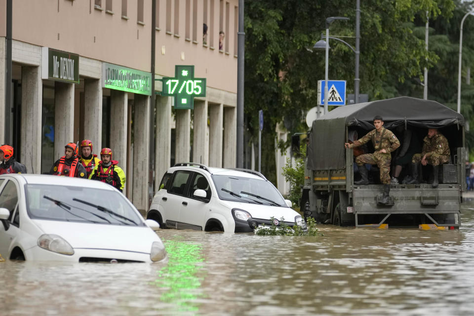 Firefighters and army soldiers arrive in a flooded street in the village of Castel Bolognese, Italy, Wednesday, May 17, 2023. Exceptional rains Wednesday in a drought-struck region of northern Italy swelled rivers over their banks, killing at least eight people, forcing the evacuation of thousands and prompting officials to warn that Italy needs a national plan to combat climate change-induced flooding. (AP Photo/Luca Bruno)