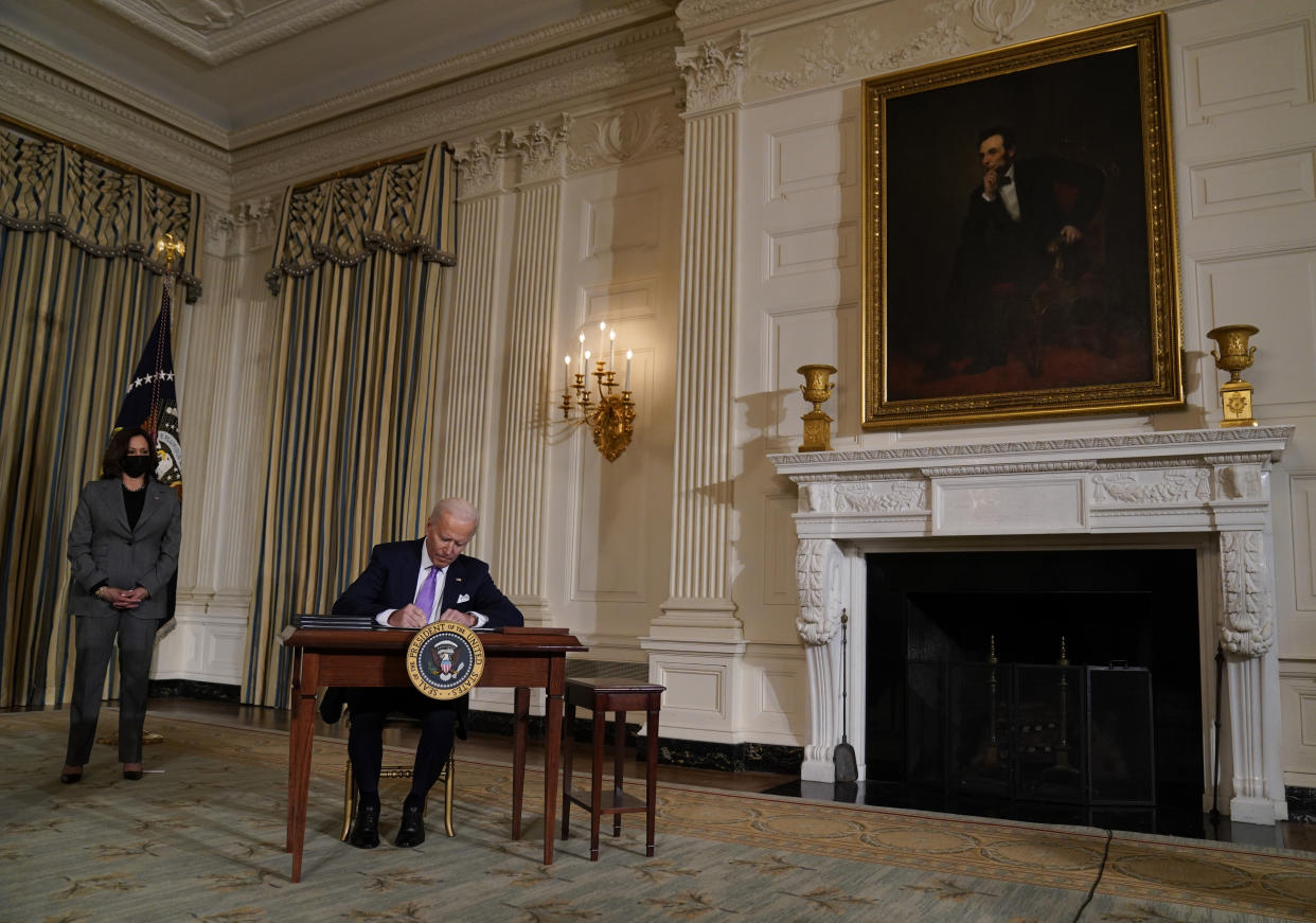 President Joe Biden signs an executive order on racial equity, in the State Dining Room of the White House, Tuesday, Jan. 26, 2021, in Washington. Vice President Kamala Harris listens at left. (Evan Vucci/AP) 