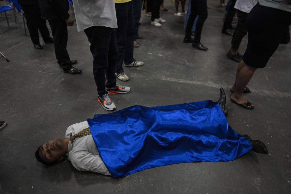 A man lies on the ground in a trance-like state during a worship service at an Assembly of God evangelical church in Rio de Janeiro, Brazil, Monday, Sept. 5, 2022. Evangelicals make up almost a third of Brazil’s population, more than double two decades ago, according to demographer Jose Eustaquio Diniz Alves. He projects they will approach 40% by 2032, surpassing Catholics. (AP Photo/Rodrigo Abd)