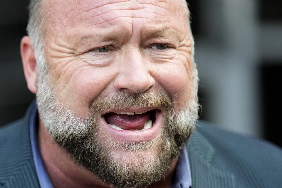 Right-wing conspiracy theorist Alex Jones speaks to the media after arriving at the federal courthouse for a hearing in front of a bankruptcy judge Friday, June 14, 2024, in Houston. The judge is expected to rule on whether to liquidate Jones' assets to help pay the $1.5 billion he owes for his false claims that the Sandy Hook Elementary School shooting was a hoax. (AP Photo/David J. Phillip)