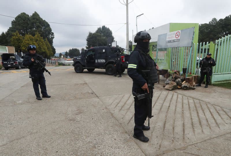 Police officers operate in an area following villagers' bloody takedown of extortionists in Texcapilla