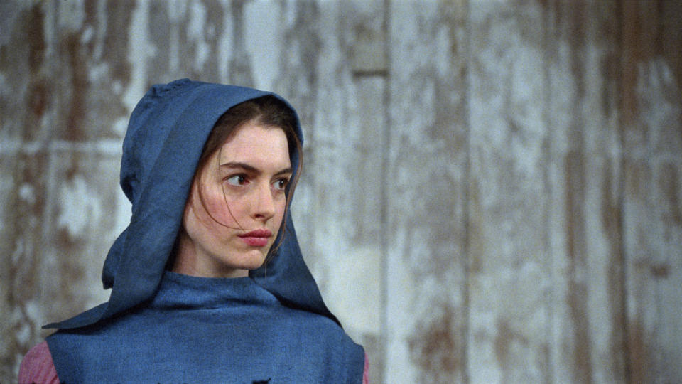 closeup of Hathaway's character wearing a hood pulled over her head
