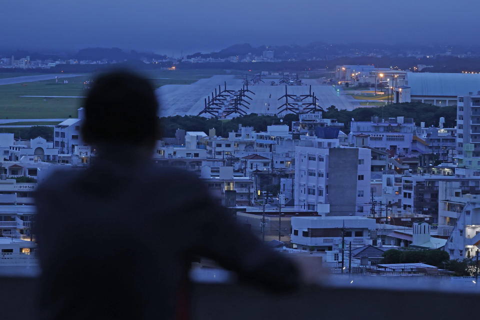 An elderly man visits a height near the U.S. Marine Air Station Futenma in Ginowan, Okinawa, Japan Sunday, May 15, 2022. Okinawa on Sunday is marking the 50th anniversary of its return to Japan after 27 years of American rule on May 15, 1972, amid protests against a continued heavy U.S. military presence and lack of support from the mainland. (Kyodo News via AP)