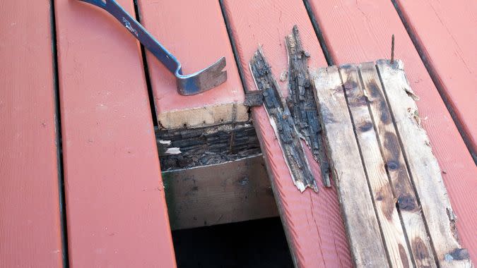 Old cedar damaged by wet rot on deck removed and prepared for new decking.