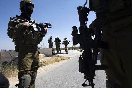 Israeli soldiers patrol during operation to locate three missing teenagers, in the West Bank city of Hebron June 18, 2014. REUTERS/Ronen Zvulun