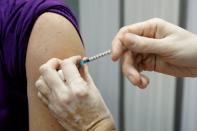 FILE PHOTO: A healthcare worker administers a dose of the Sputnik V vaccine to her collegue in Podgorica