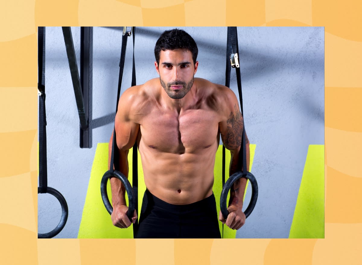 close-up of fit, muscular man doing ring dips at the gym