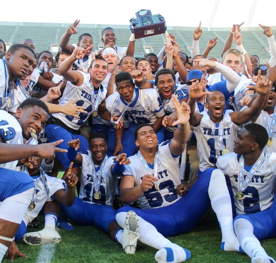 Trinity Christian raises the trophy after their victory over Clearwater Central Catholic in the 2013 FHSAA Class 3A state football championship at the Citrus Bowl.