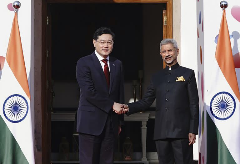 En esta foto difundida por el Ministerio indio de Asuntos Exteriores, el ministro indio de Asuntos Exteriores, S. Jaishankar, a la derecha, da la bienvenida a su homólogo chino, Qin Gang, a su llegada a la reunión de ministros de Asuntos Exteriores del G20, en Nueva Delhi, India, el jueves 2 de marzo de 2023.
