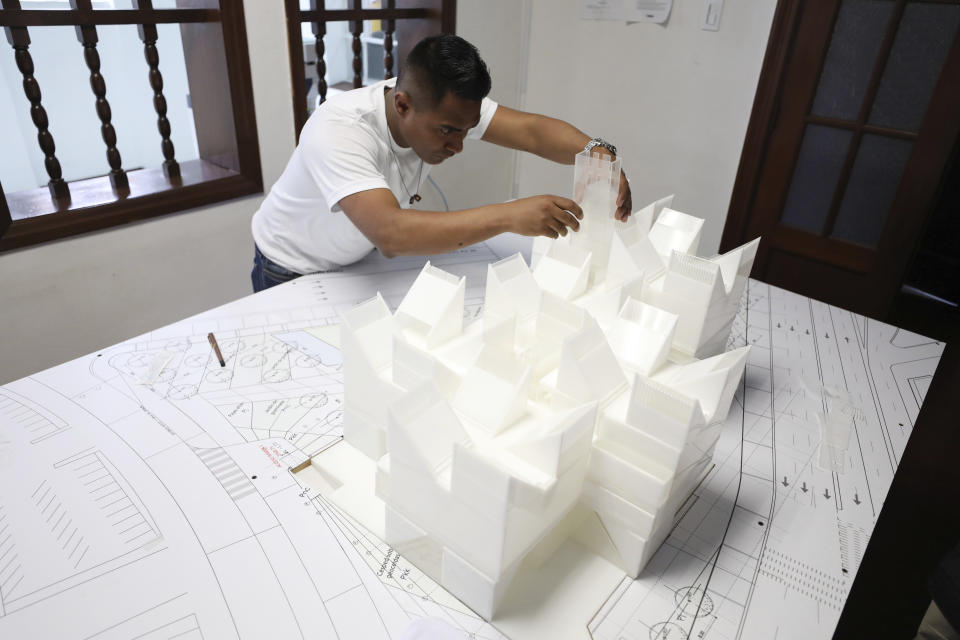 An architect works on the model of the planned Museum of Memory in Bogota, Colombia, Thursday, Dec. 12, 2019. Colombia’s government hopes to build a large museum paying homage to the millions of victims of the country’s long civil conflict. (AP Photo/Fernando Vergara)