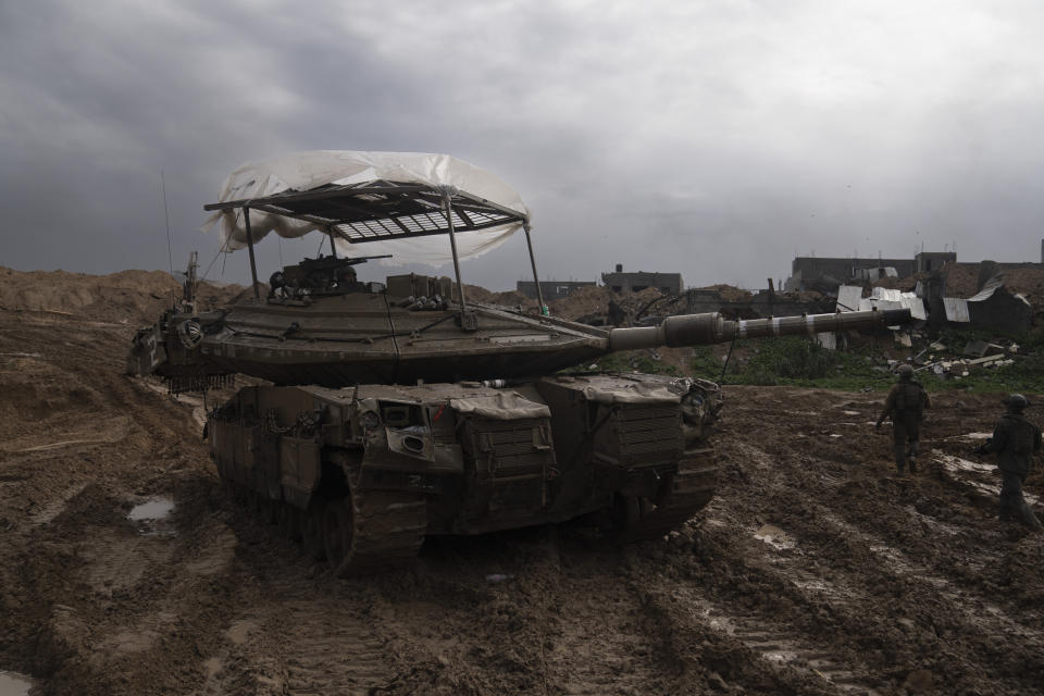 Israeli soldiers walk by a tank during the ground offensive on the Gaza Strip in Khan Younis, Saturday, Jan. 27, 2024. (AP Photo/Sam McNeil)