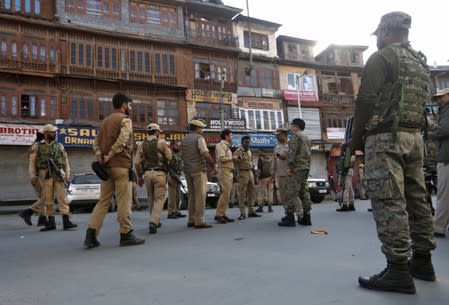 Indian police officers stand at the site of a grenade attack in Srinagar
