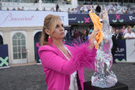Stacy Nicks wipes down the trophy for the $3 million Pegasus World Cup Invitational horse race, Saturday, Jan. 27, 2024, at Gulfstream Park in Hallandale Beach, Fla. (AP Photo/Wilfredo Lee)