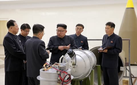 Kim Jong-un with regime engineers at an undisclosed location - Credit: Korea News Service via AP
