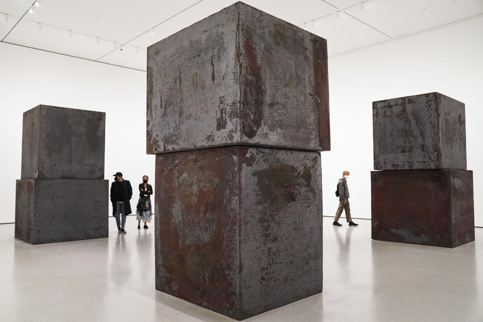 FILE - Guests browse Richard Serra's "Equal" at the Museum of Modern Art in the new fall exhibition spaces, Nov. 13, 2020, in New York. Serra, known for turning curving walls of rusting steel and other malleable materials into large-scale pieces of outdoor artwork that are now dotted across the world, died Tuesday, March 26, 2024, at his home in Long Island, N.Y. He was 85. (AP Photo/John Minchillo, File)