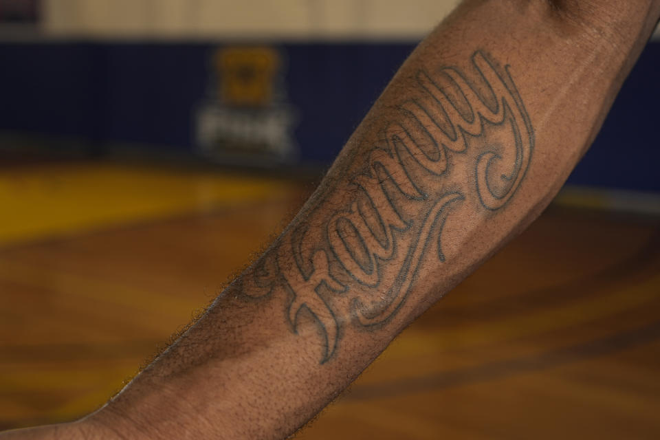 Fisk University basketball player Jeremiah Armstead displays a tattoo on his forearm of the word "family" during a portrait session Wednesday, March 6, 2024, in Nashville, Tenn. The formerly homeless Armstead will receive the U.S. Basketball Writers Association 2024 Perry Wallace Most Courageous award at the NCAA Final Four basketball tournament. (AP Photo/George Walker IV)