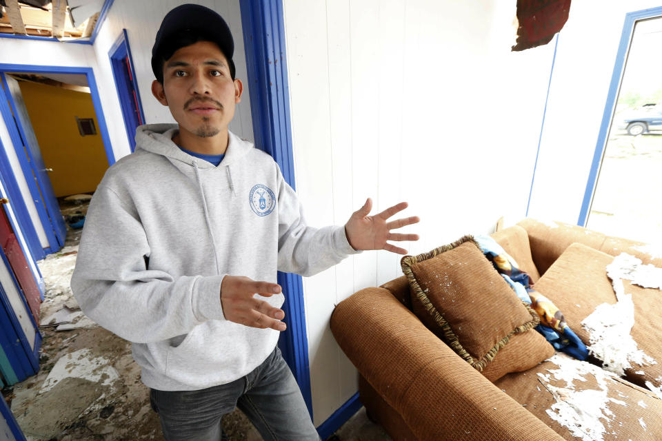 Andres Aguilar, a native of Guatemala, says Friday, April 19, 2019, that he and other family members were very scared when they heard the winds of a possible tornado hit their Morton, Miss., home, Thursday afternoon. Augilar said he and his family hid under the house's door frame as much of the roof was torn off and the windows were blown out. Strong storms again roared across the South on Thursday, topping trees and leaving a variety of damage in Mississippi, Louisiana and Texas. (AP Photo/Rogelio V. Solis)