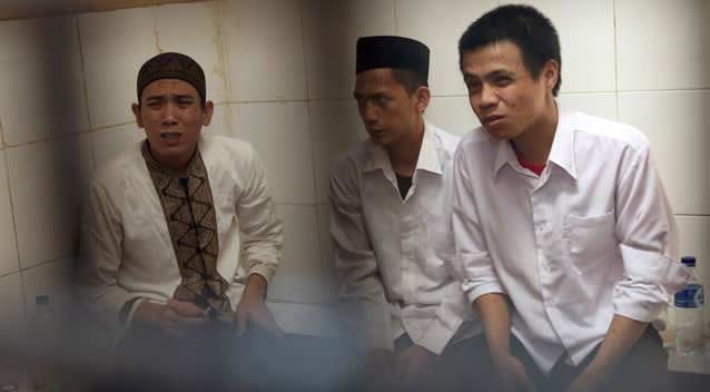 Child sexual abuse suspects, from left, Syahrial, Zainal Abidin and Virgiawan Amin sit inside a holding cell as they wait for the start of their trial at South Jakarta District Court in Jakarta, Indonesia, Wednesday, Aug. 27, 2014. Photo: Getty