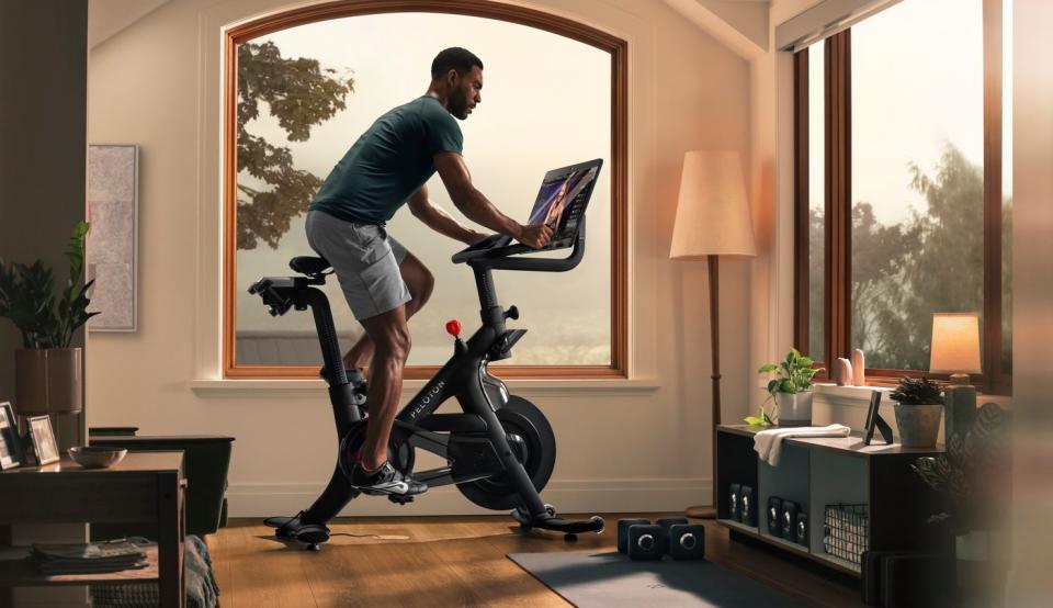 Person riding a Peloton in living room.