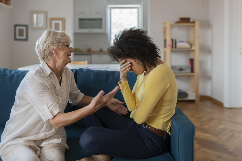 Two women engaged in a comforting conversation, one consoles the other who appears upset