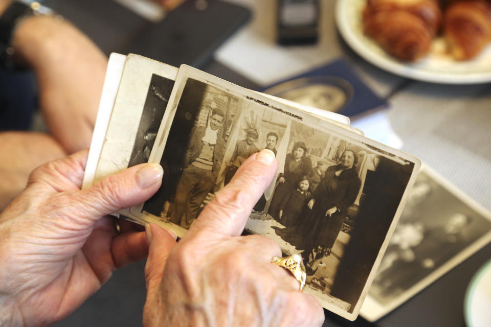 Eugenie Cayet, 84, shows family photos Wednesday, Oct.13, 2021 in Paris. Her father, having enlisted in the French Army, was deported from Drancy and never came back, killed in Auschwitz. Critics of Eric Zemmour, a rabble-rousing television pundit and author with repeated convictions for hate speech, include people like Cayet, who lost relatives to the Holocaust. They are outraged by his repeated comments that have sugarcoated wartime France's collaboration with the extermination of French Jews. (AP Photo/John Leicester)