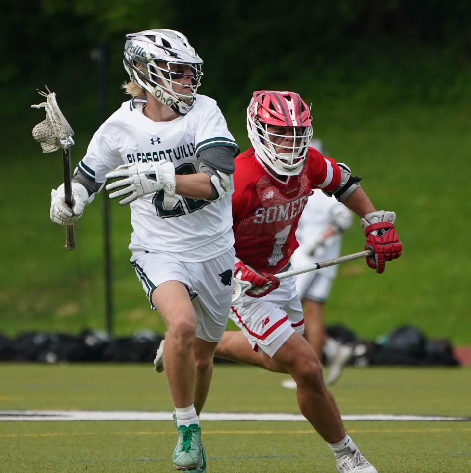 Pleasantville's Emmet McDermott (22) works past Somers' Dean Palazzolo (1) during their 11-10 overtime win in boys lacrosse at Pleasantville High School on Tuesday, May 14, 2024.
