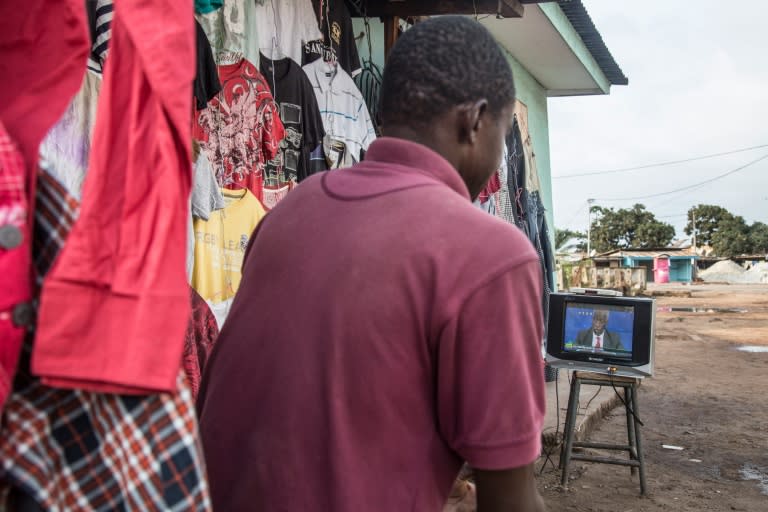 A man watches a televised political debate in Port-Gentil ahead of presidential elections in Gabon