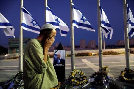 A man reacts next to a portrait of former Israeli President Shimon Peres, as he lies in state at the Knesset plaza, the Israeli parliament, in Jerusalem September 29, 2016. REUTERS/Ammar Awad