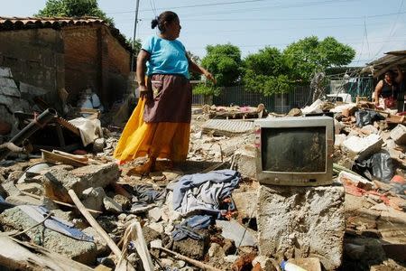 A woman stands amidst the remains of a house after an earthquake struck the southern coast of Mexico late on Thursday, in Union Hidalgo, Mexico September 9, 2017. REUTERS/Jorge Luis Plata