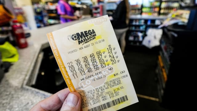 A Mega Millions ticket is seen as a person makes a purchase inside a convenience store.