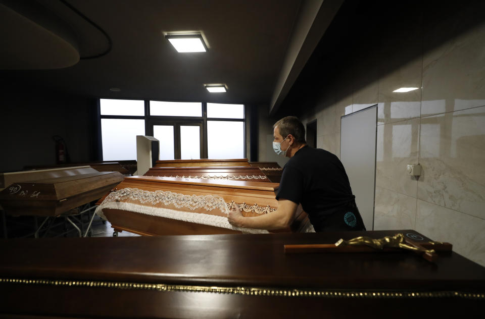 A worker prepares a casket to be incinerated at a crematorium in Ostrava, Czech Republic, Thursday, Jan. 7, 2021. The biggest crematorium in the Czech Republic has been overwhelmed by mounting numbers of pandemic victims. With new confirmed COVID-19 infections around record highs, the situation looks set to worsen. Authorities in the northeastern city of Ostrava have been speeding up plans to build a fourth furnace but, in the meantime, have sought help from the government’s central crisis committee for pandemic coordination. (AP Photo/Petr David Josek)